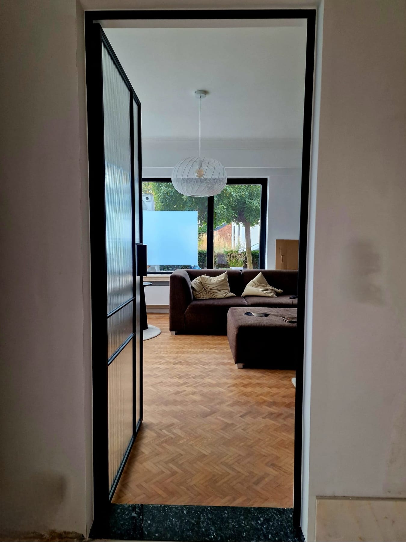 Daglicht dat door een glazen binnendeur met matglas in de woonkamer valt
