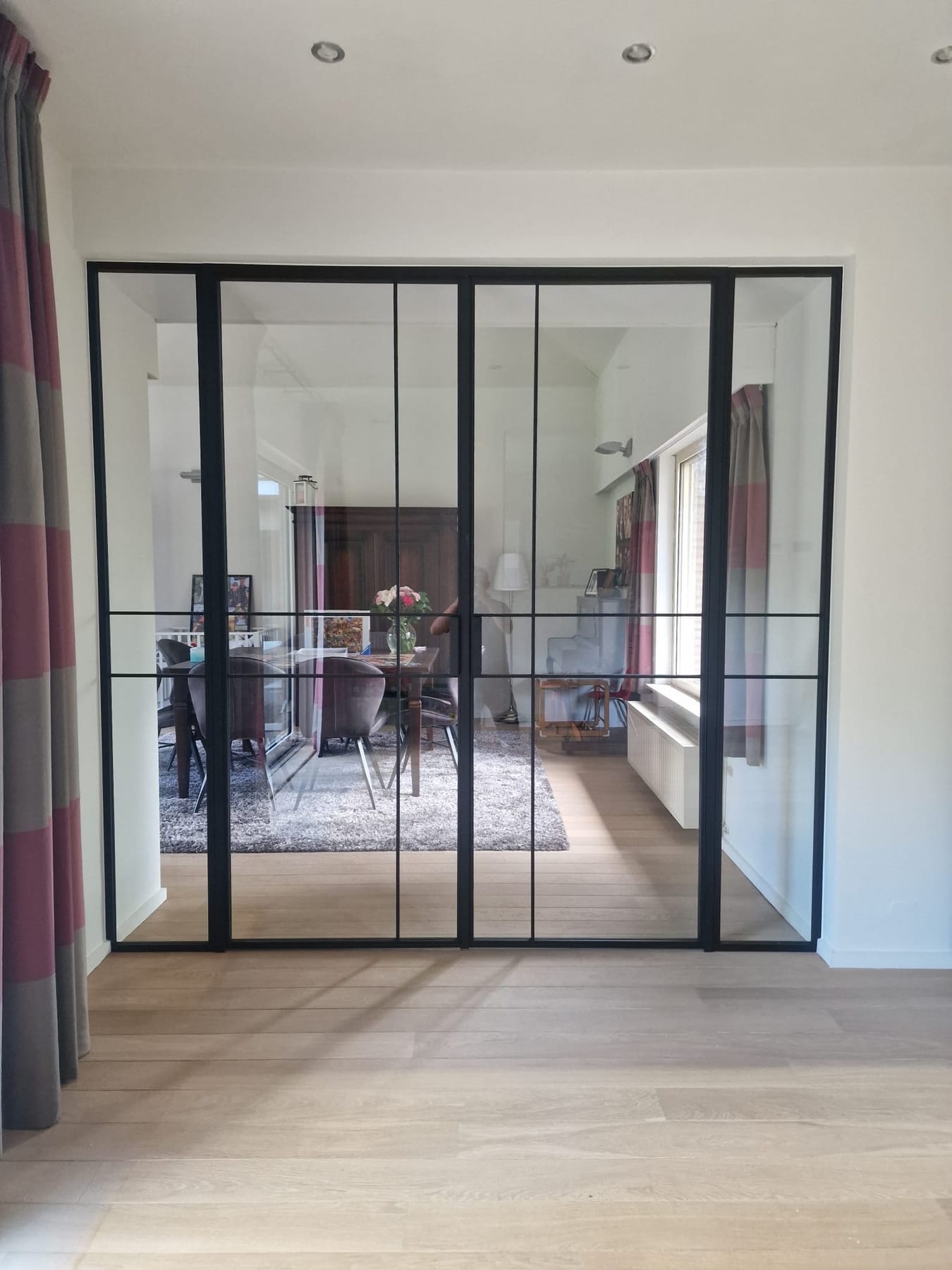 Zwarte stalen dubbele binnendeur met glas in een moderne eetkamer