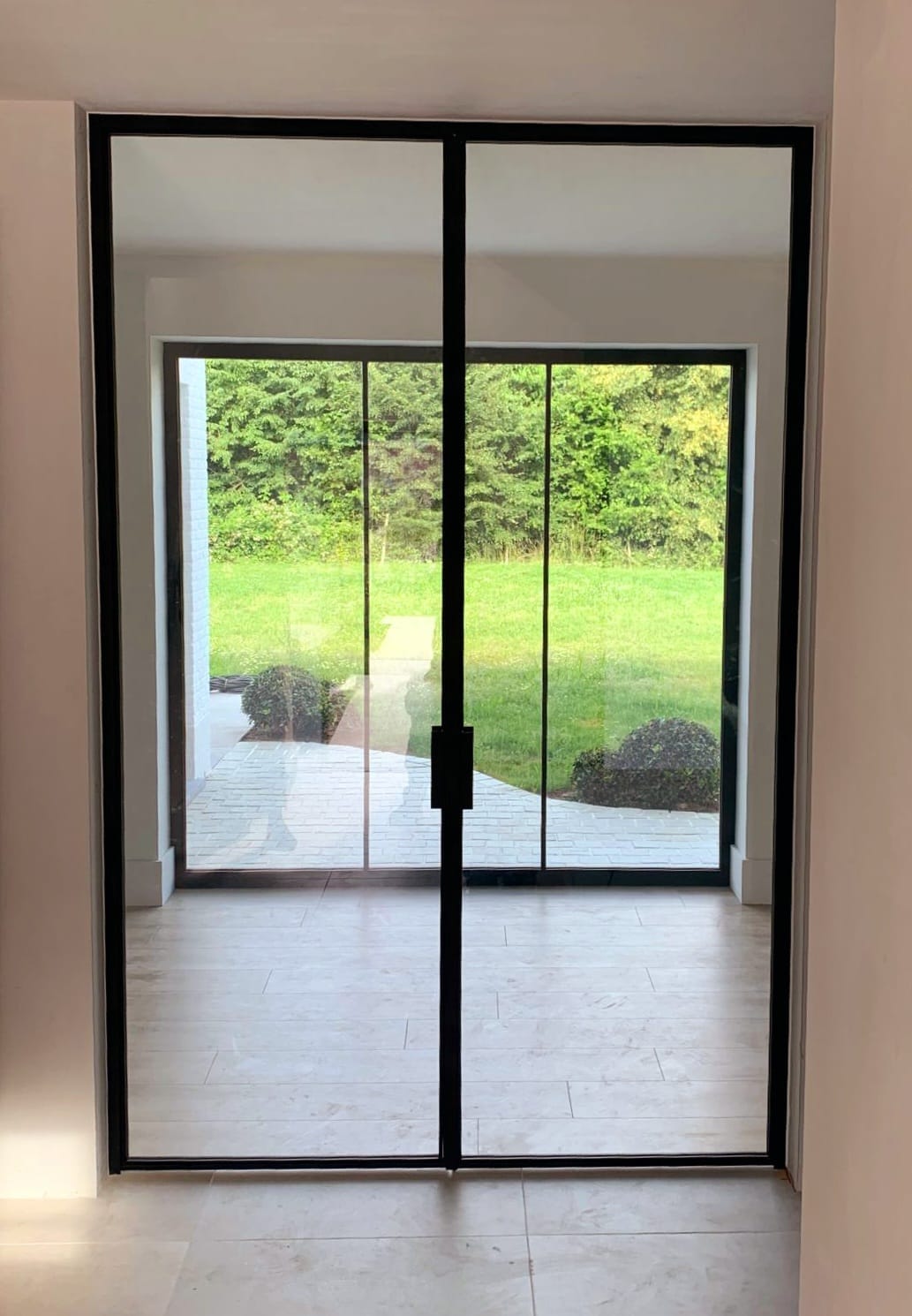 Grote stalen pivotdeur met glas