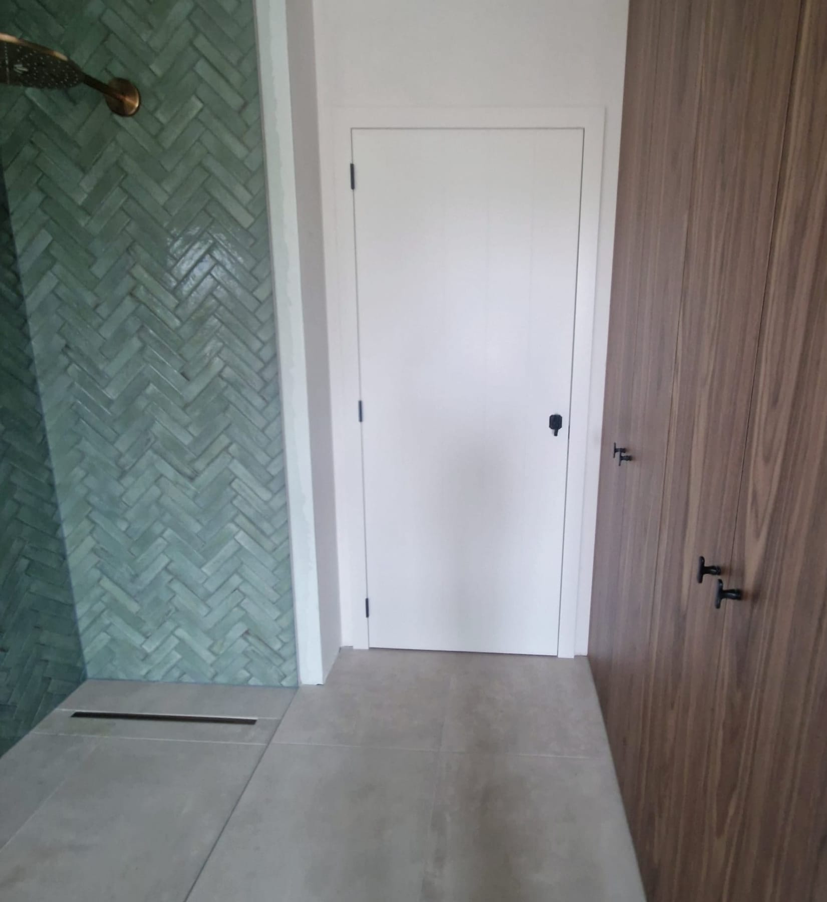 Witte superlak deur in een badkamer met groene tegels